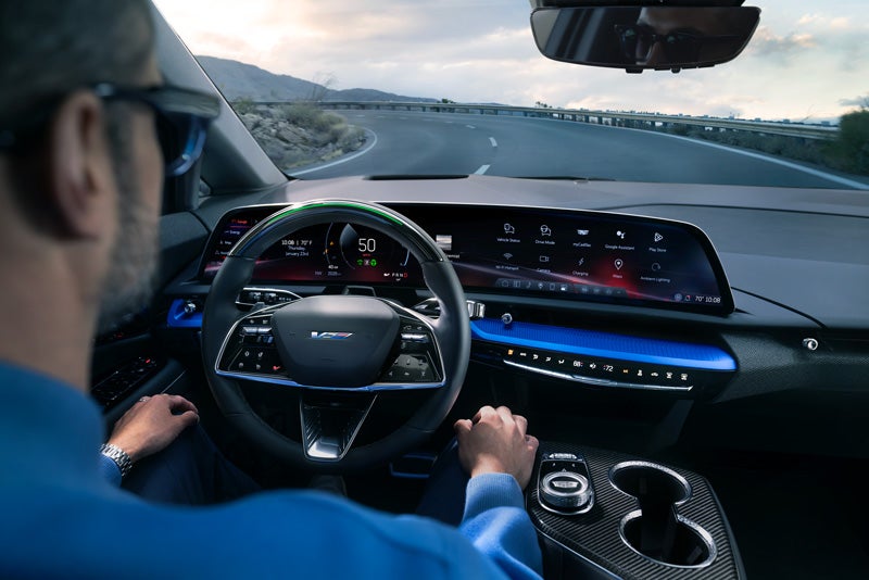 Front View of the 2026 OPTIQ-V Driving Through the Dusk Utilizing its Headlights | Cable Dahmer Cadillac of Kansas City in Kansas City MO