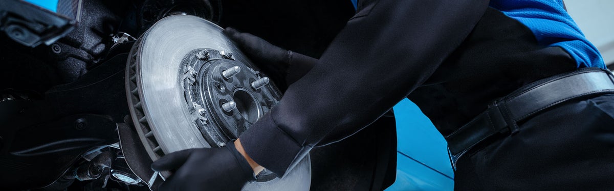 Photo of a mechanic installing car brakes on a vehicle