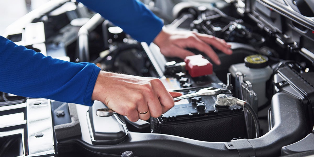 Factory-trained technician servicing a Cadillac in the service bay