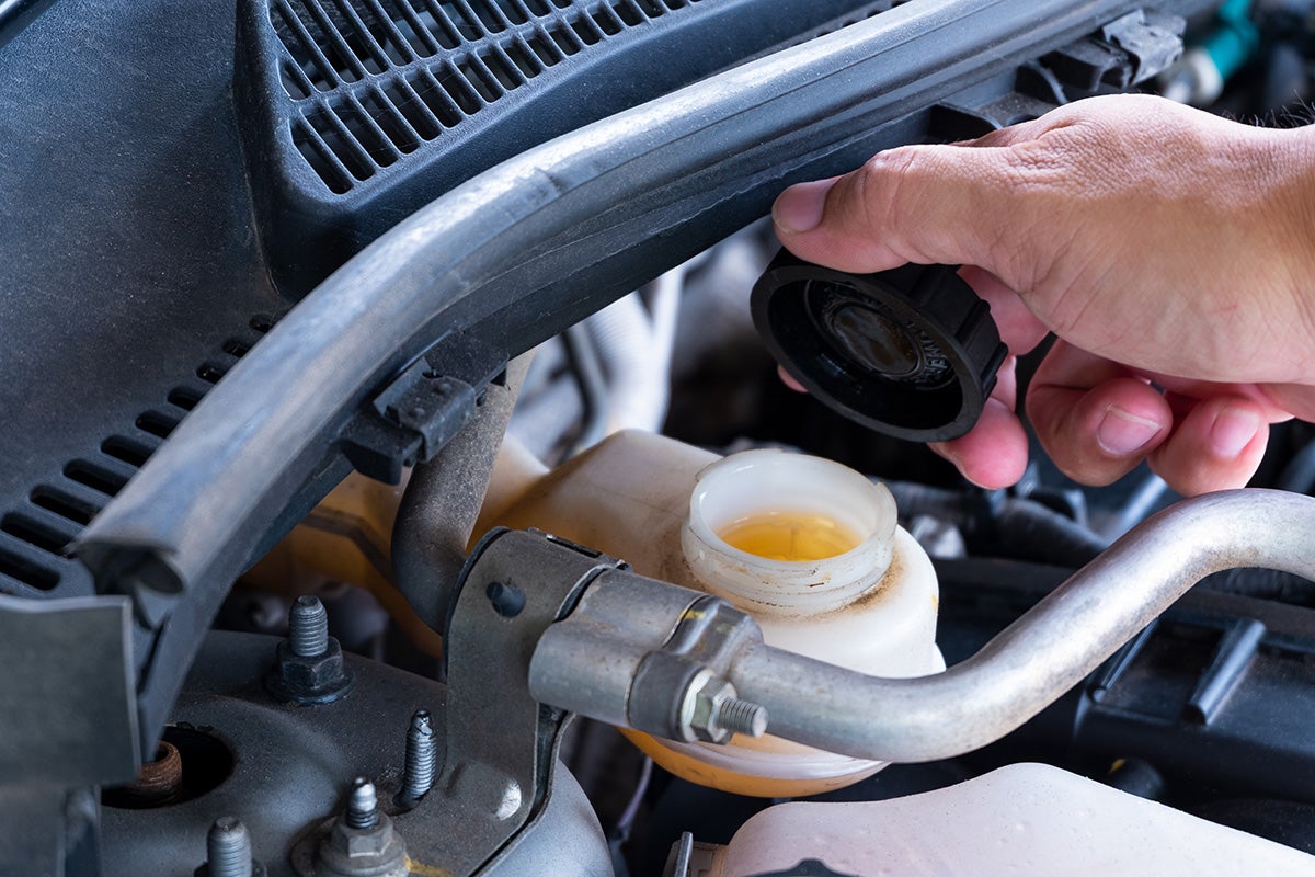 Cadillac certified service technician performing transmission fluid service at Cable Dahmer of Kansas City